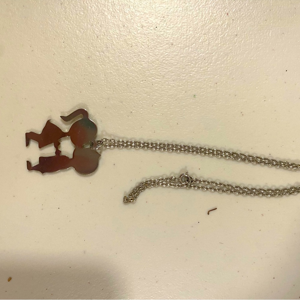 Silver tone necklace with kissing boy and girl charm